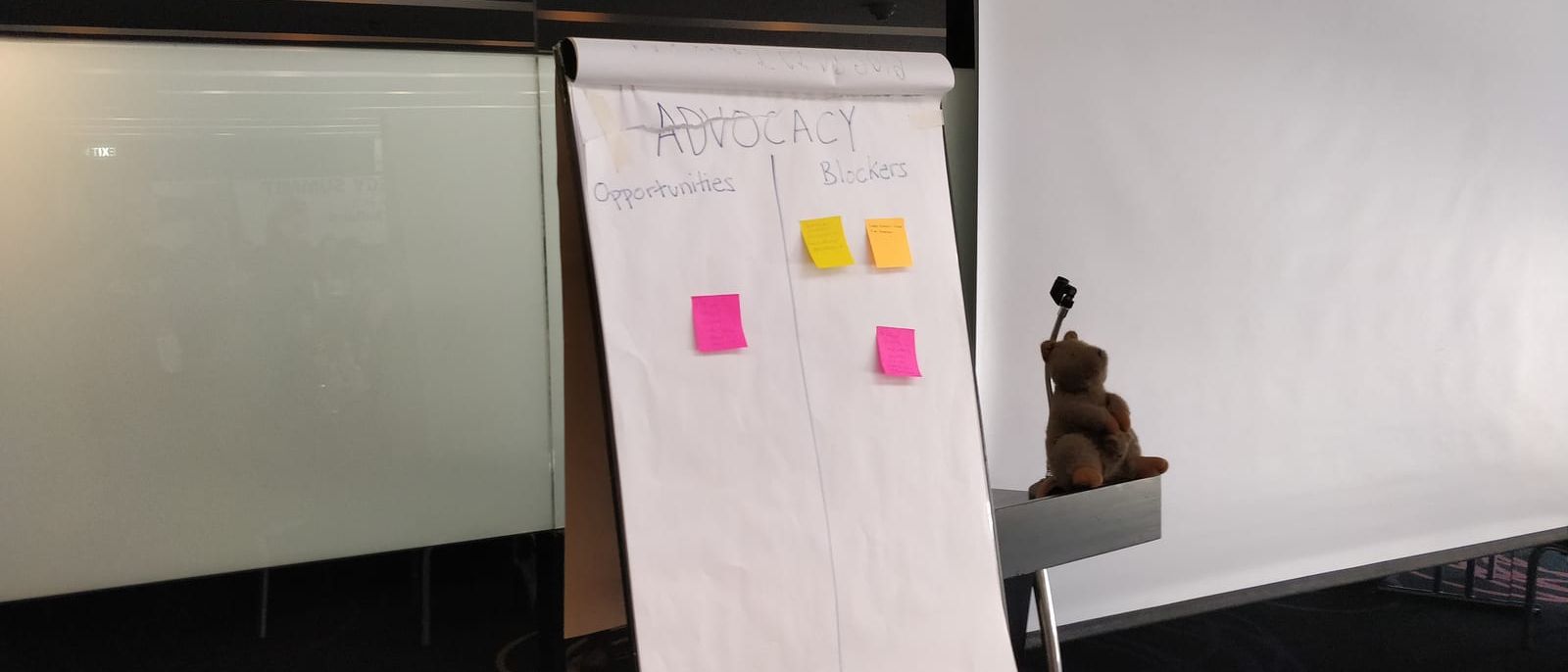 Flipchart in einem Seminarraum mit zwei Spalten und bunten Haftnotizen